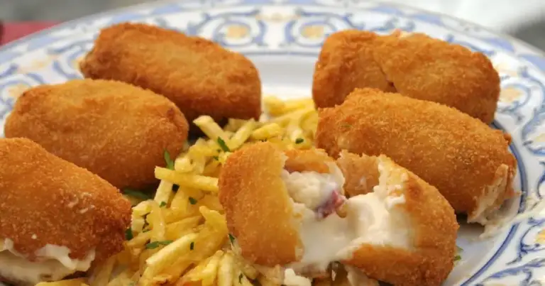 Plato con croquetas fritas doradas y papas paja acompañadas