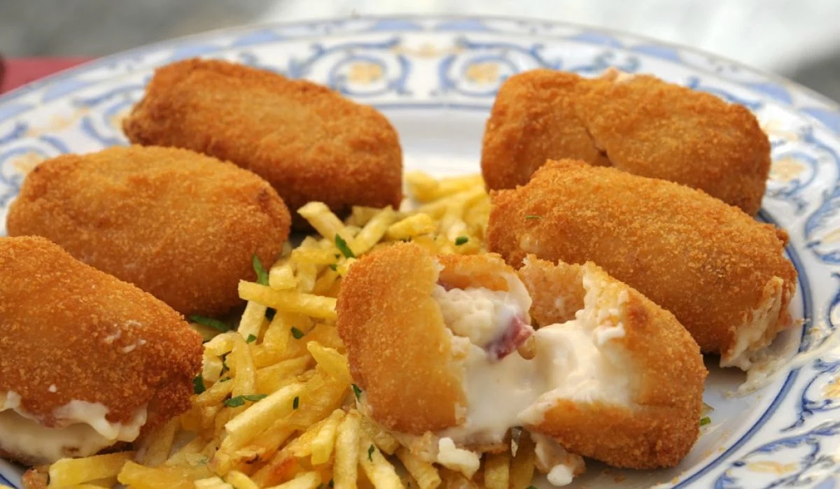 Plato con croquetas fritas doradas y papas paja acompañadas