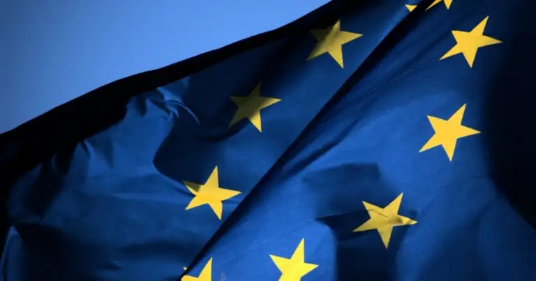 Bandera azul de la Unión Europea con estrellas doradas ondulando