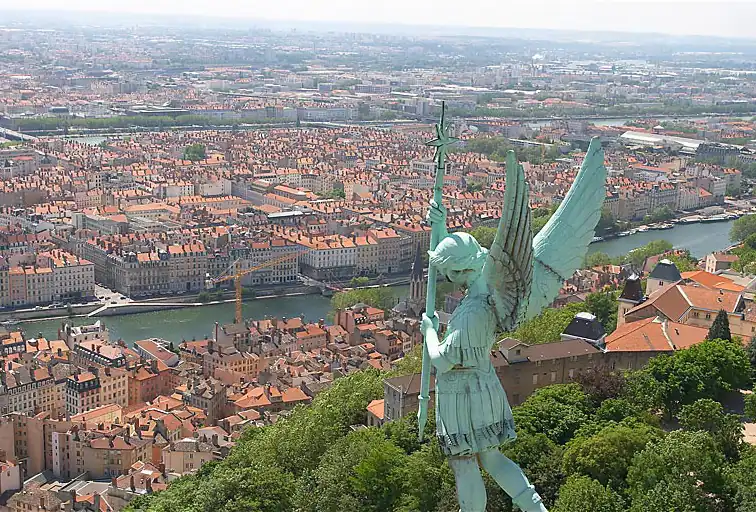 Basílica blanca con torres y estatua verdosa desde mirador de ciudad
