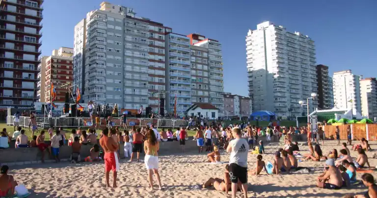 Playa concurrida con edificios altos de apartamentos al fondo