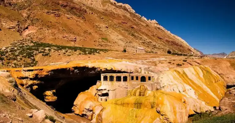 Puente de piedra natural con estructura de vivienda en ladera árida de montaña