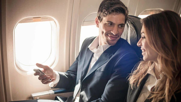 Pareja de pasajeros sentados en ventanilla durante vuelo de avión