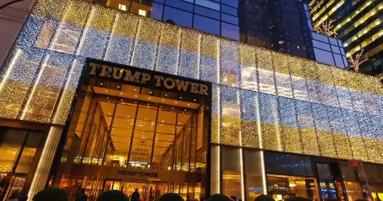 Fachada de edificio iluminado de noche con letras TRUMP TOWER