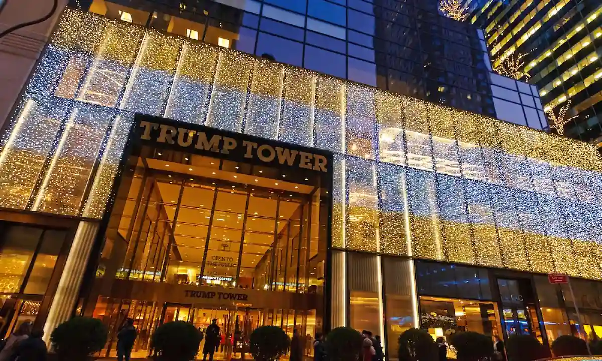 Fachada de edificio iluminado de noche con letras TRUMP TOWER