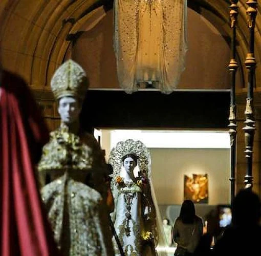 Capas y vestimentas litúrgicas bordadas en exhibición dentro de galería religiosa