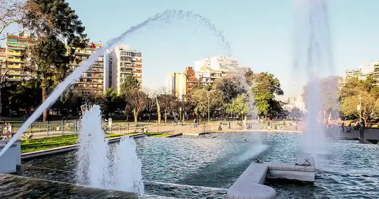 Parque con fuentes activas rodeado de edificios de altura modernos
