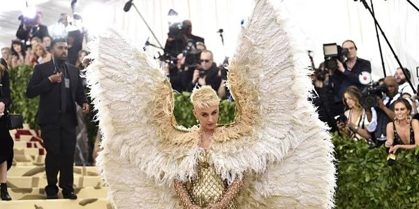 Persona con pieza de vestuario elaborada con alas grandes blancas en evento formal