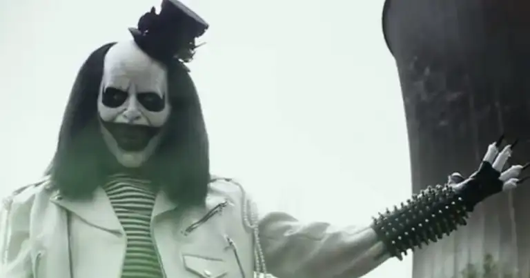 Persona con maquillaje de calavera y atuendo blanco con detalles verdes