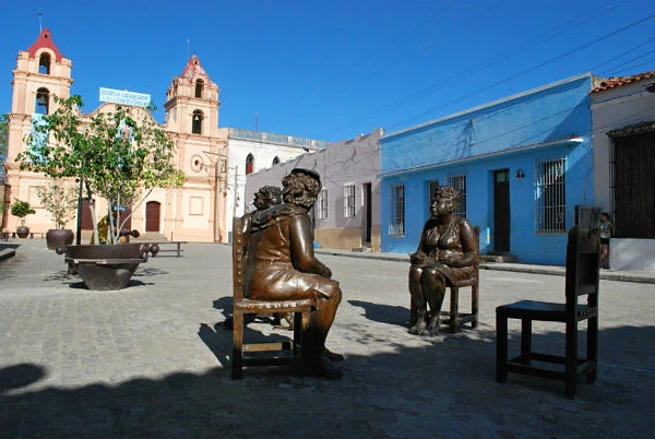 Plaza colonial con iglesia y estatuas de bronce en Camagüey