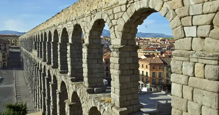 Acueducto de piedra con múltiples arcos arqueados sobre la ciudad
