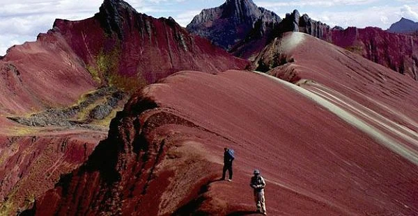 Montañas de colores vivos con trekistas en sendero andino