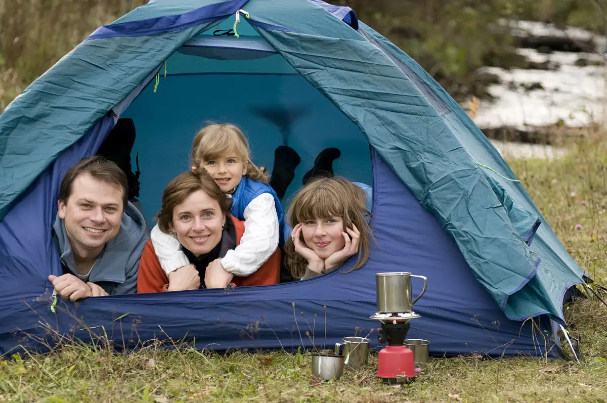 Familia feliz usando una de las mejores carpas para acampar mejores carpas para acampar en familia