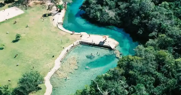 Río turquesa rodeado de selva verde con sendero para visitantes