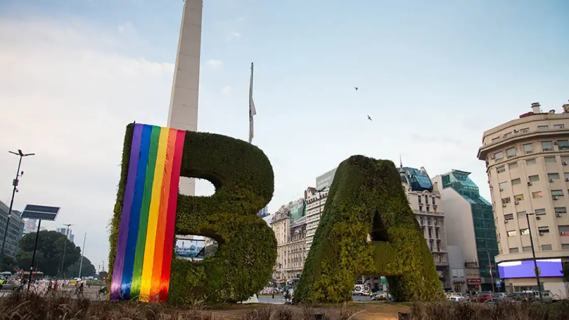 Letras BA cubiertas de musgo con obelisco de Buenos Aires de fondo