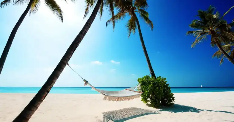 Playa tropical con palmeras, hamaca y aguas turquesas
