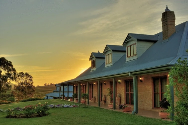 Bodega de lujo rodeada de viñedos al atardecer en región vinícola