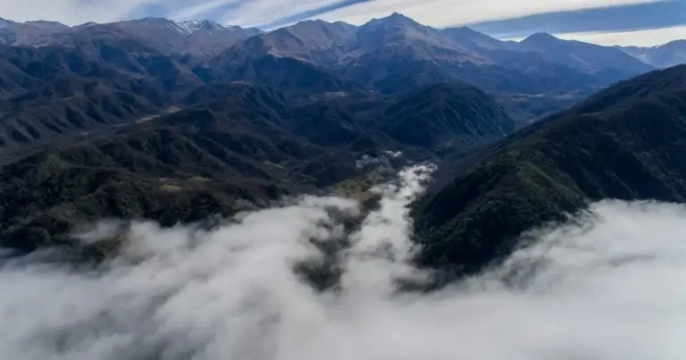 Sierras montañosas con niebla en valles y vegetación alpina