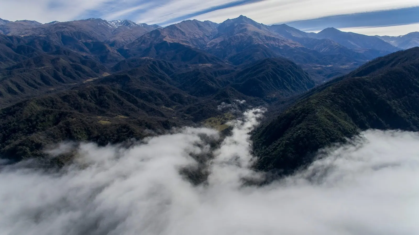 Sierras montañosas con niebla en valles y vegetación alpina