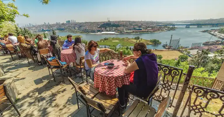 Viajeros en terraza de aeropuerto con vista a la ciudad de Estambul