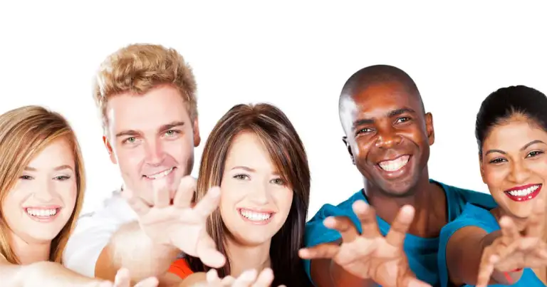 Grupo de amigos de diferentes orígenes sonriendo y extendiendo los brazos
