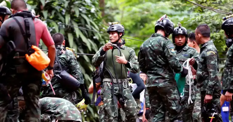 Grupo de rescatistas y niños emergiendo en zona de bosque y cueva