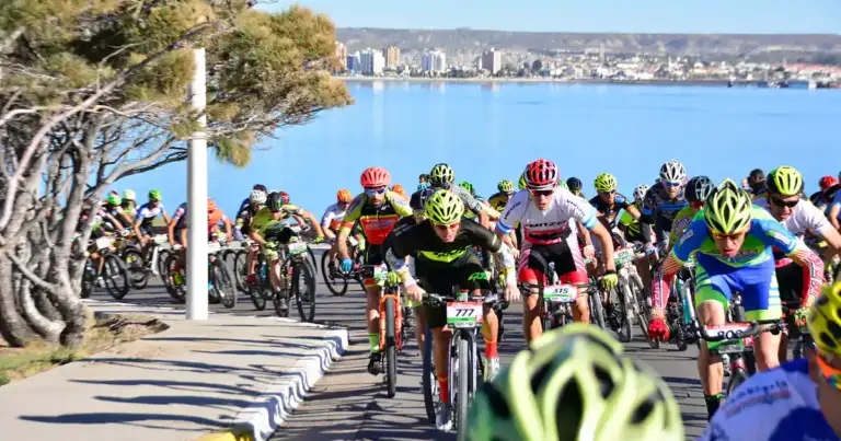 Carrera de mountain bike en ruta costera con ciudad de fondo