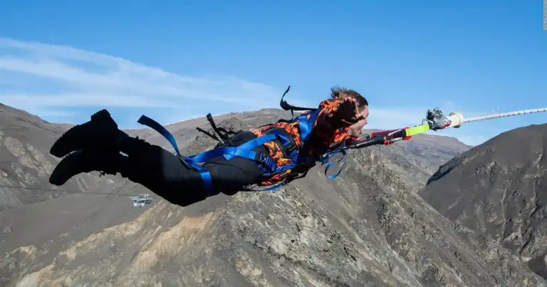 Persona suspendida en vuelo por catapulta humana sobre montañas