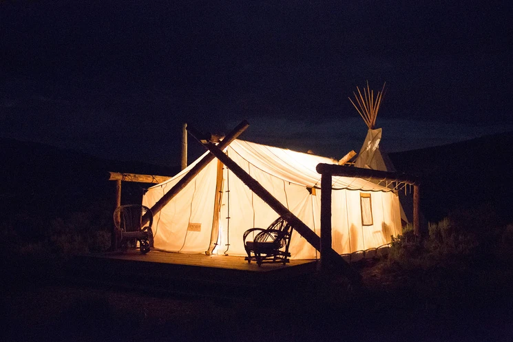 Tienda glamping de lujo iluminada desde adentro de noche