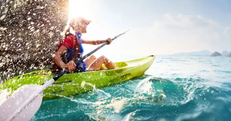 Kayak en olas turquesas con remero y salpicaduras de agua
