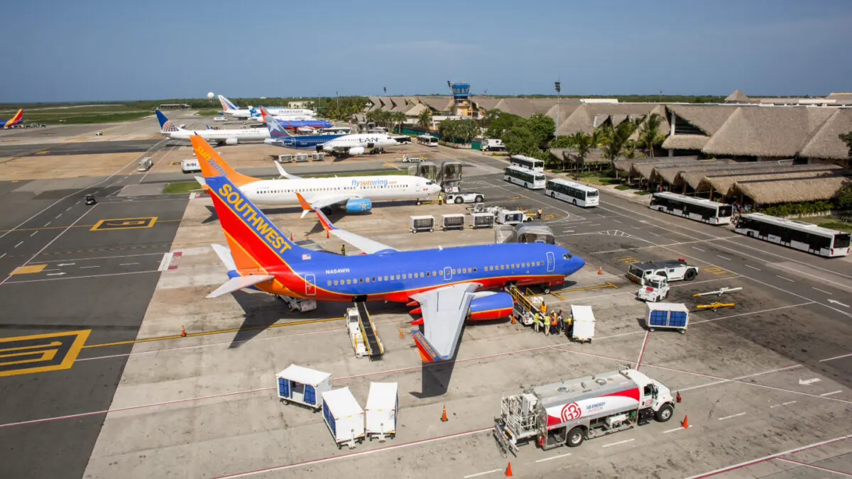 Avión de pasajeros estacionado en pista de aeropuerto con equipos