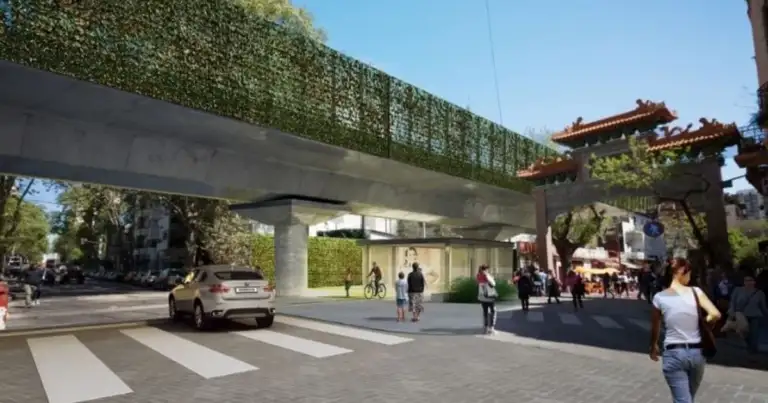Viaducto ferroviario sobre calle con tráfico y personas bajo él