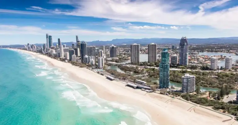Playa con aguas turquesas, arena blanca y rascacielos