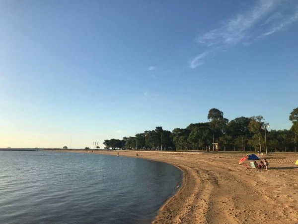 Playa de arena con árboles y personas