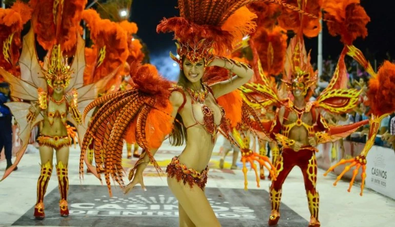 Comparsa de carnaval con disfraces de plumas doradas en desfile