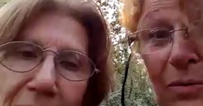 Dos personas adultas con lentes sonriendo frente a la cámara