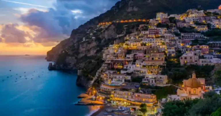 Pueblo costero con casas coloridas en acantilado al atardecer