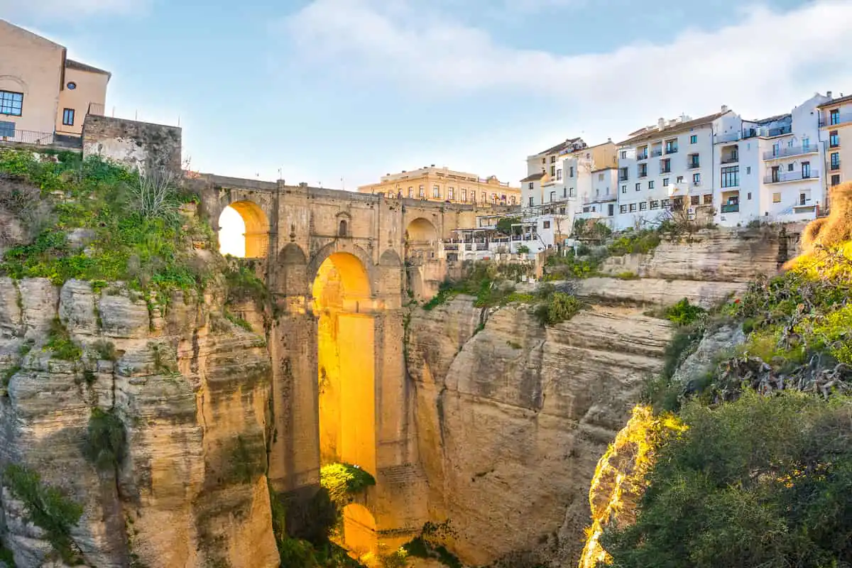 Puente de piedra sobre garganta profunda con edificios de piedra