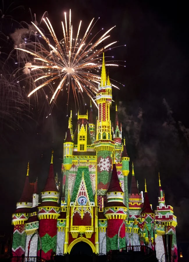 Castillo de Cenicienta de Disney iluminado con fuegos artificiales navideños