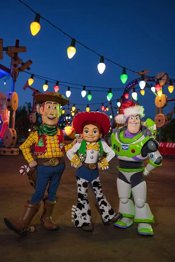 Personajes de Toy Story disfrazados bajo luces festivas