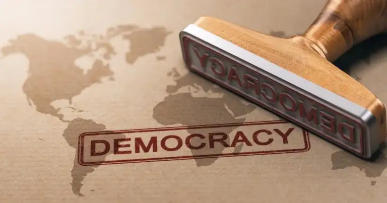 Sello de caucho con texto DEMOCRACY sobre mapa mundial