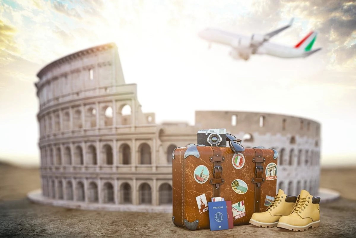 Coliseo antiguo con maleta de viaje vintage, calcetines y avión al fondo