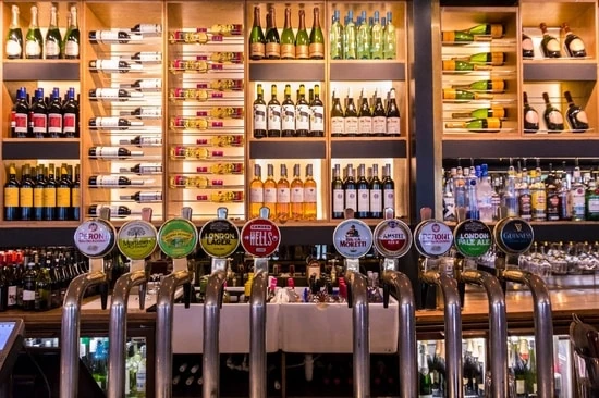 Interior de pub tradicional con barra y botellas de bebidas alcohólicas