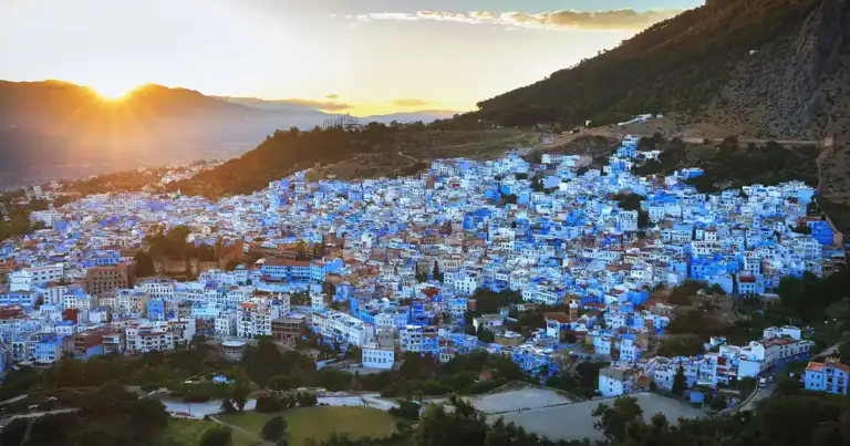 Pueblo montañoso con casas pintadas de azul intenso durante el atardecer