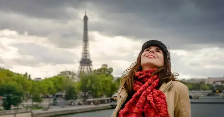 foto de una mujer en puente de paris con la torre eiffel atras