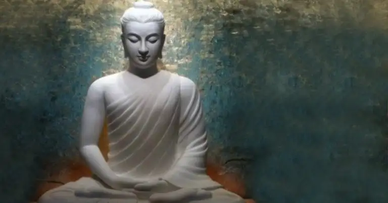 Estatua blanca de Buda en posición de loto con rostro sereno y manos descansadas