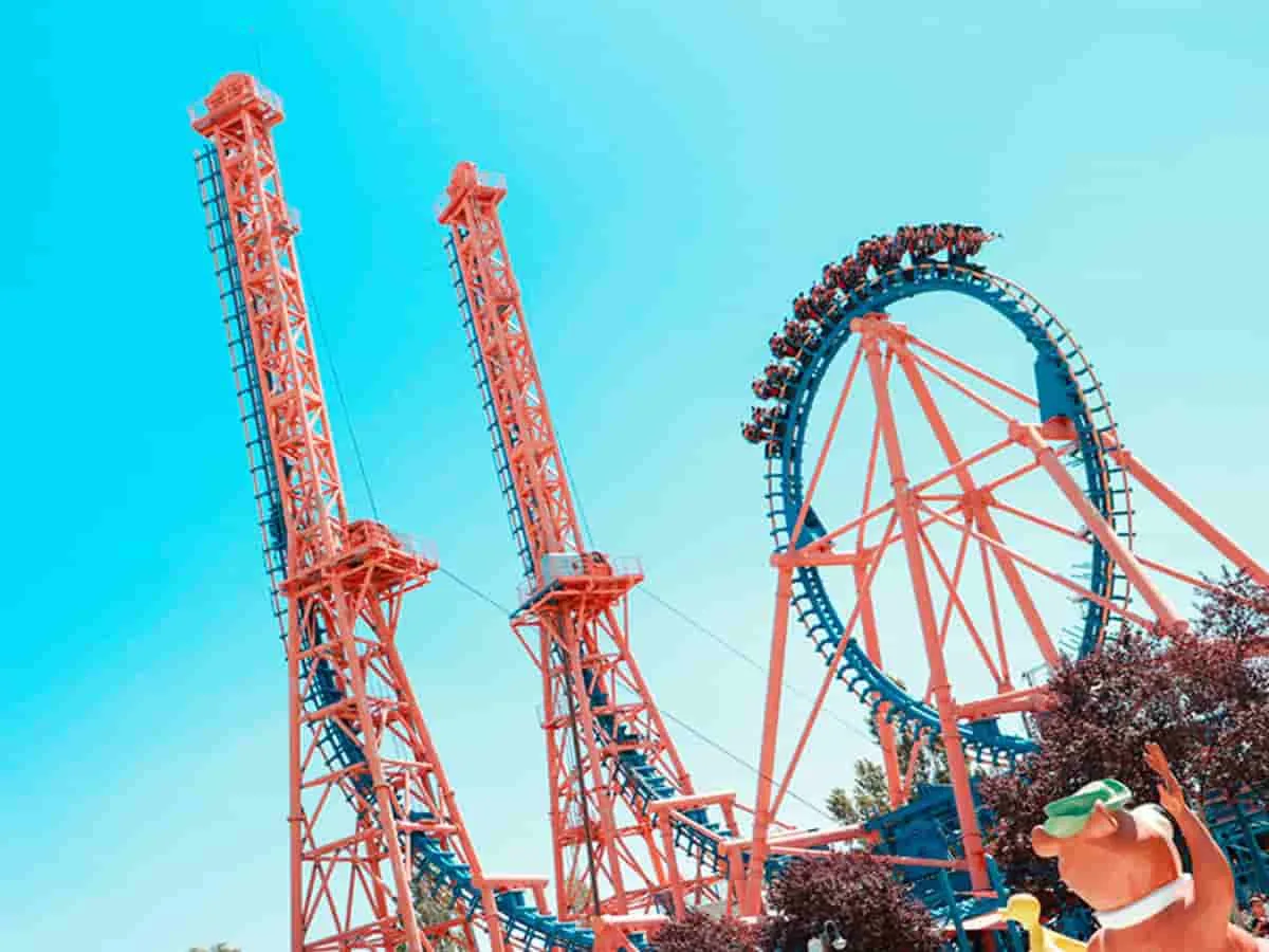 Montaña rusa roja y azul con estructura de acero compleja en parque temático