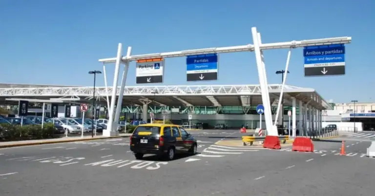 Entrada a estacionamiento con estructura blanca de señalización y peaje automático