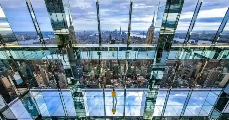 Interior de rascacielos con pisos de cristal transparente permitiendo vista a paisaje urbano