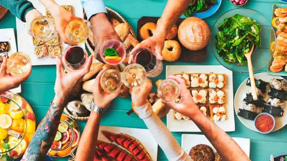 Grupo compartiendo comidas variadas en mesa colorida